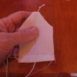 tie knot in elastic cord and position to wrong side of tea bag front as shown