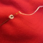 using embroidery floss, stitch around each eyelet to secure.