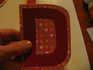 cut out a shape slightly larger from contrast paper