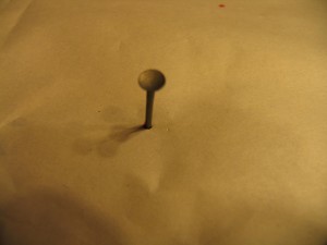 drive a nail through fabric to make a hole