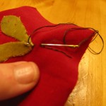 make a line using embroidery floss. Start at the leaf and then stitch to the top of garland piece