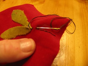 make a line using embroidery floss. Start at the leaf and then stitch to the top of garland piece