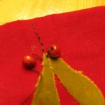 sew two wooden beads at the top of leaves