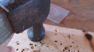 lay a board on top of tag and carefully tap it down with a hammer