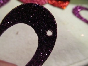 punch a hole using an eyelet punch or something that makes small holes