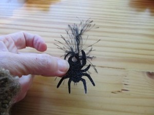 punch hole in spider and tie a piece of fuzzy yarn in the hole