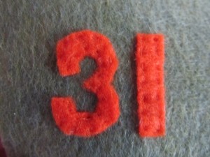hand stitch or glue numbers onto pockets