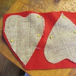 cut out hearts from felt fabric that is slightly larger than the burlap heart