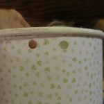 punch two holes as shown near the top of the container